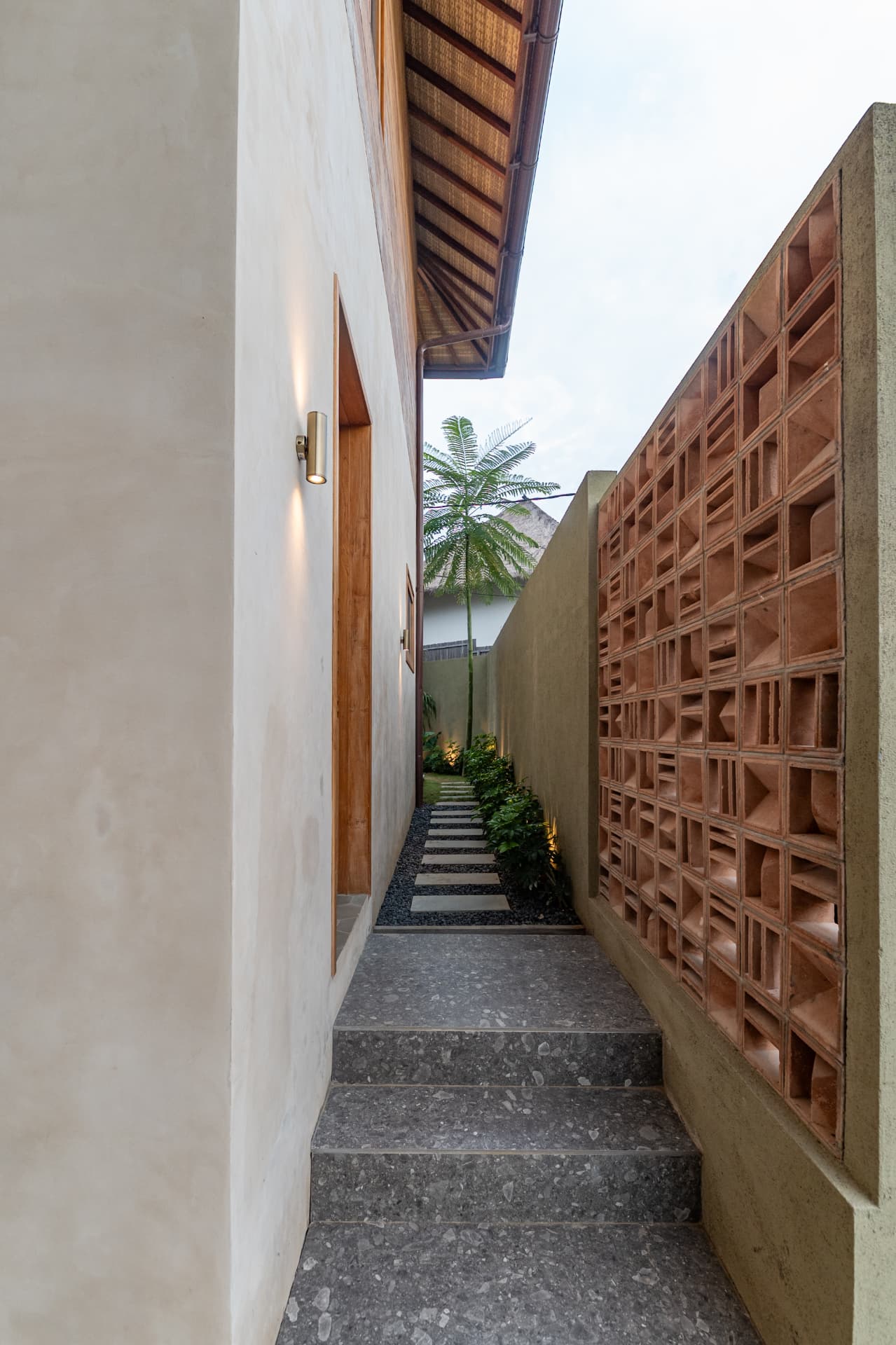 Side passage with a terracotta breeze-block screen