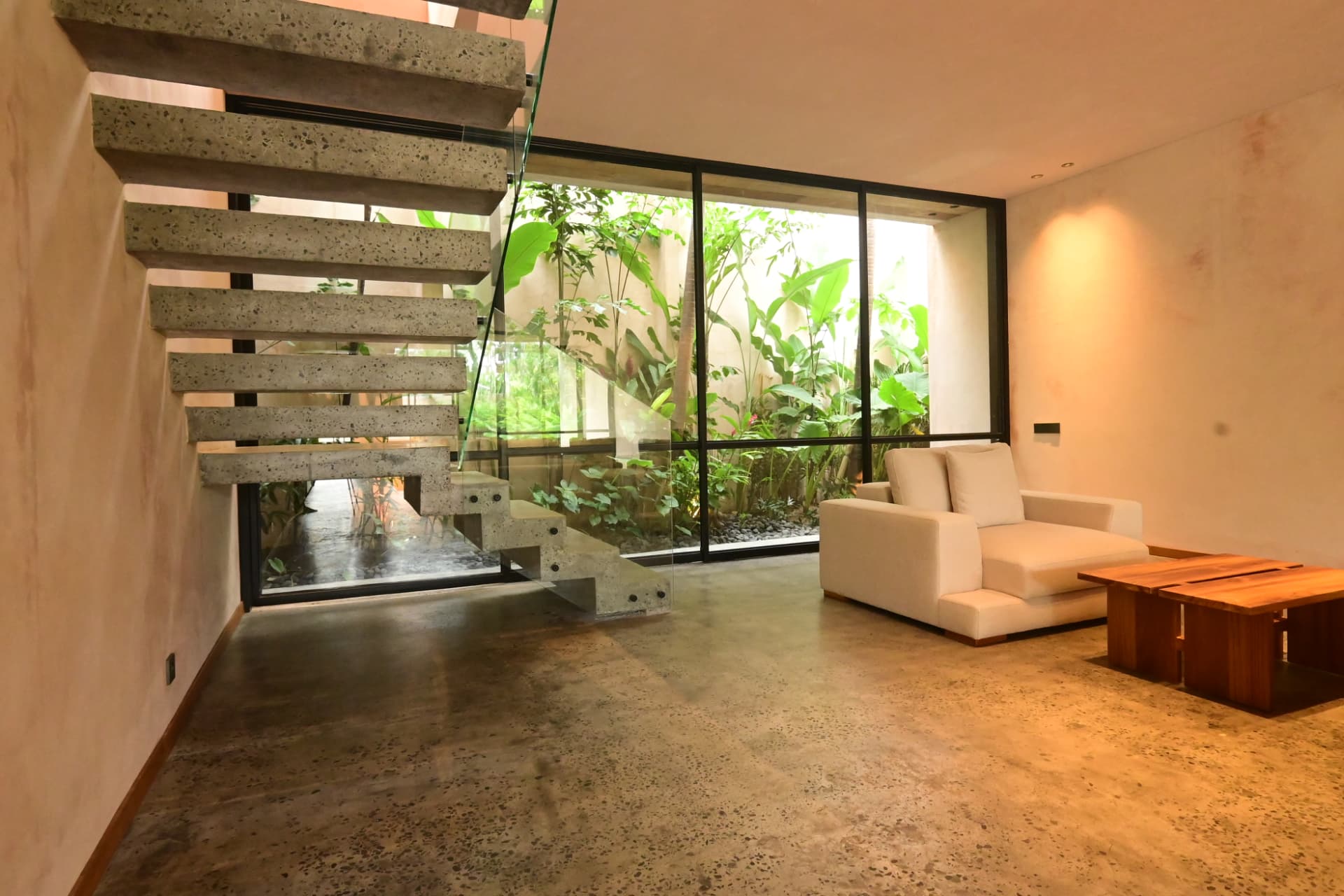 Pererenan 1 — living space with floating terrazzo stair and courtyard garden