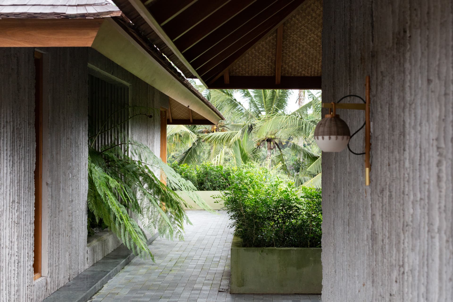 Covered walkway with cast planters and brass lighting
