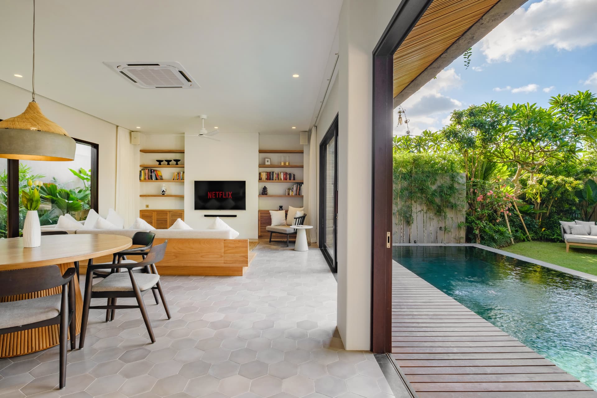 Villa Uni — open-plan living and dining opening onto the pool deck