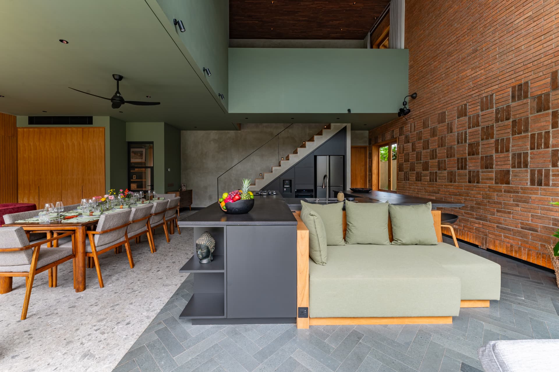Umalas 1 — living and dining volume with brick wall and concrete stair