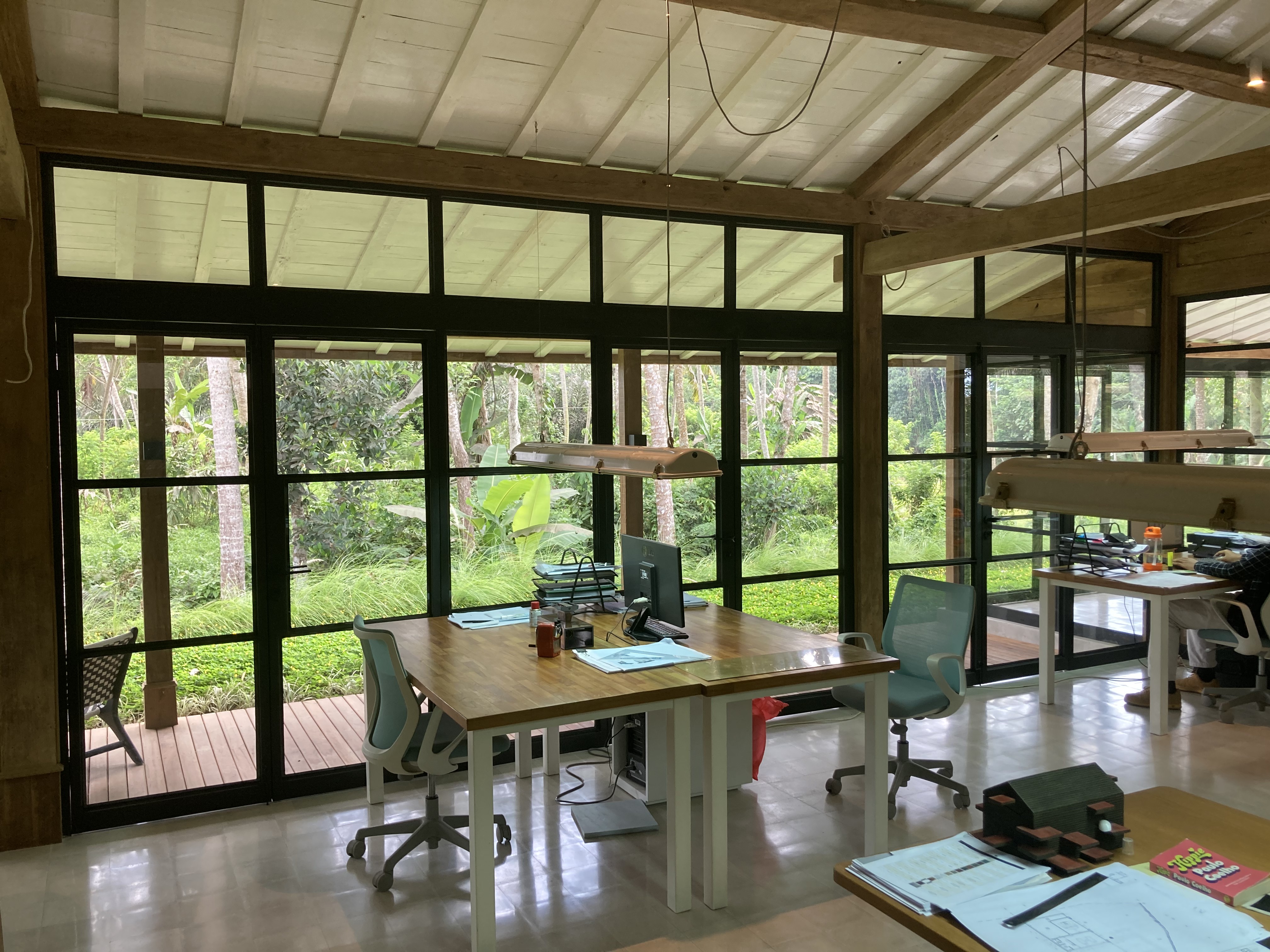 Ubud 3 — glazed workspace interior opening onto the timber deck and pool