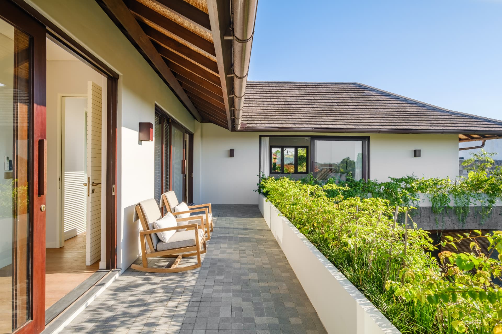 Villa Uni — upper terrace with timber roof structure and planted edge