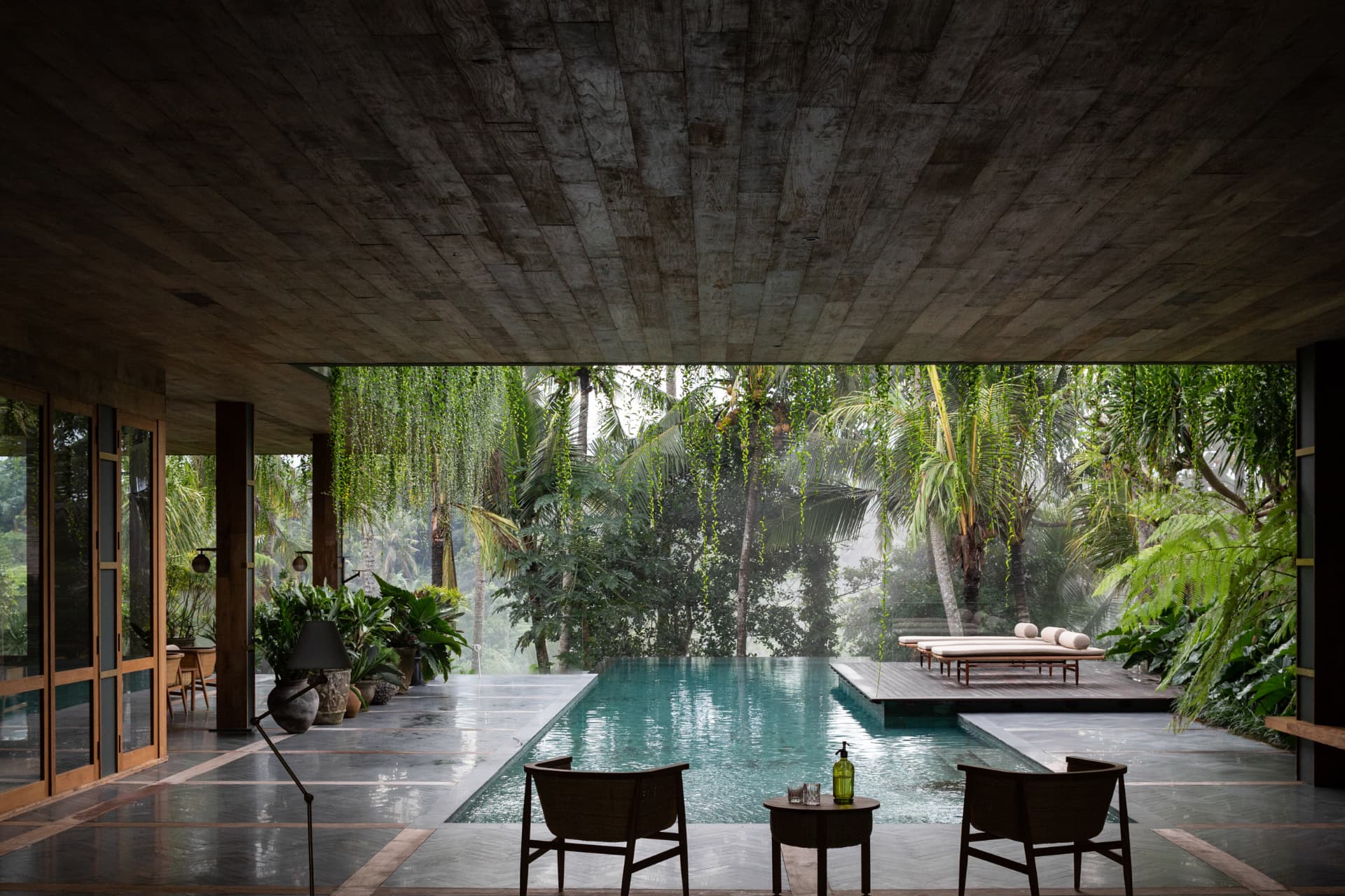 Ubud 1 — board-formed concrete soffit framing the lap pool and jungle