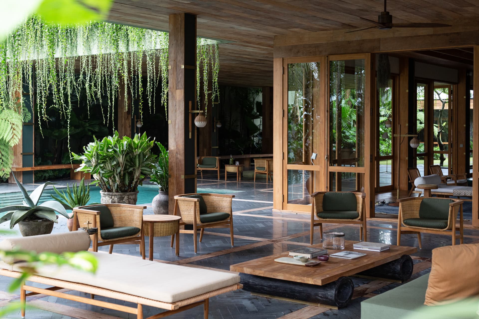 Open-air living pavilion beside a pool