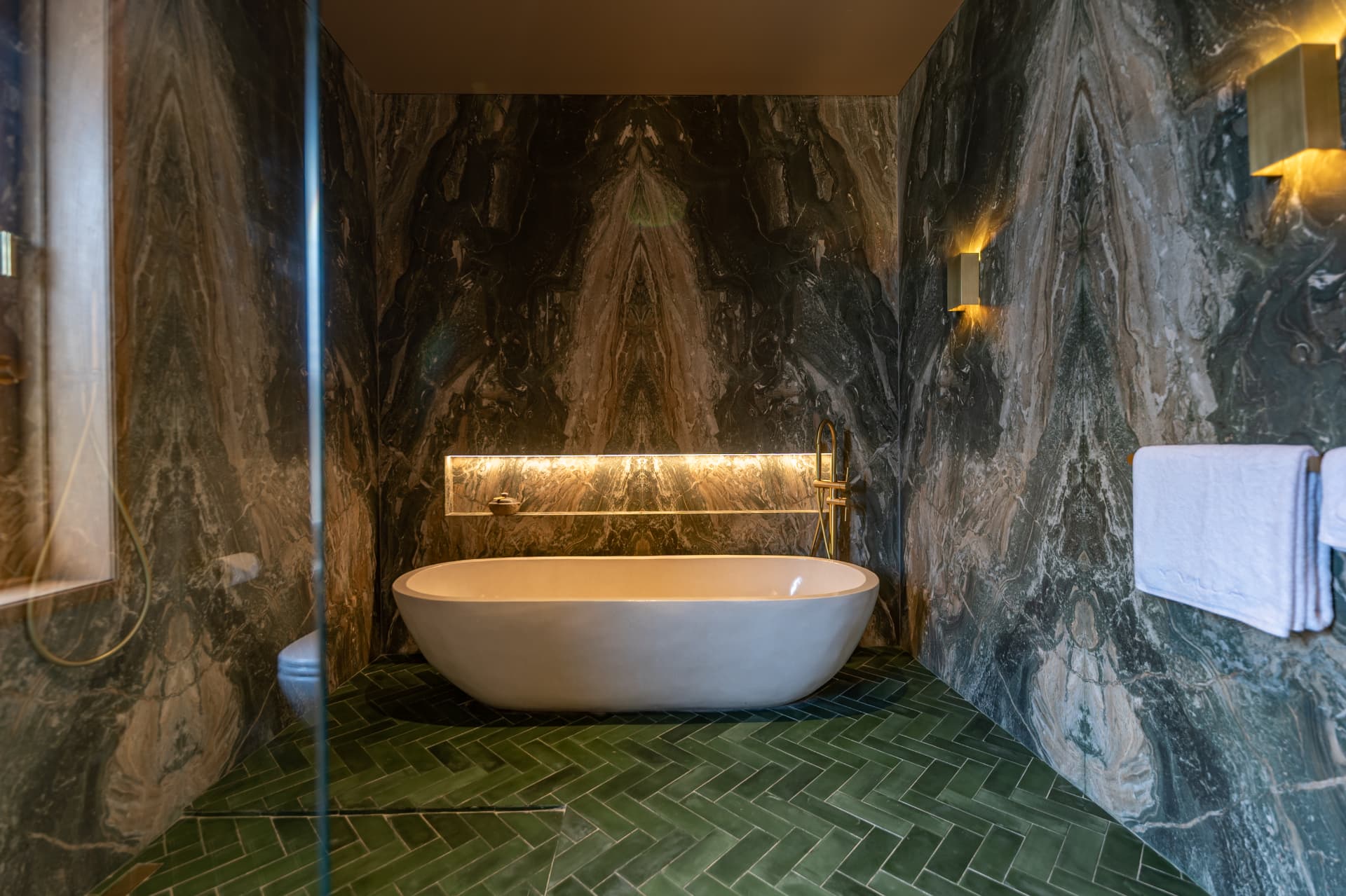 Marble bathroom with freestanding tub and herringbone floor