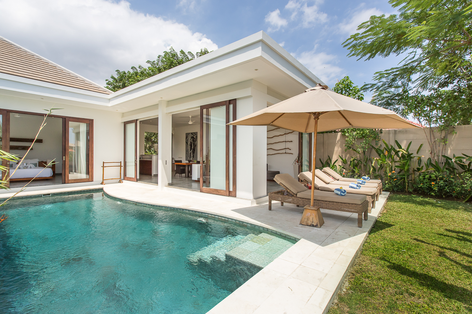Compact pool villa with sliding timber doors and a shaded terrace