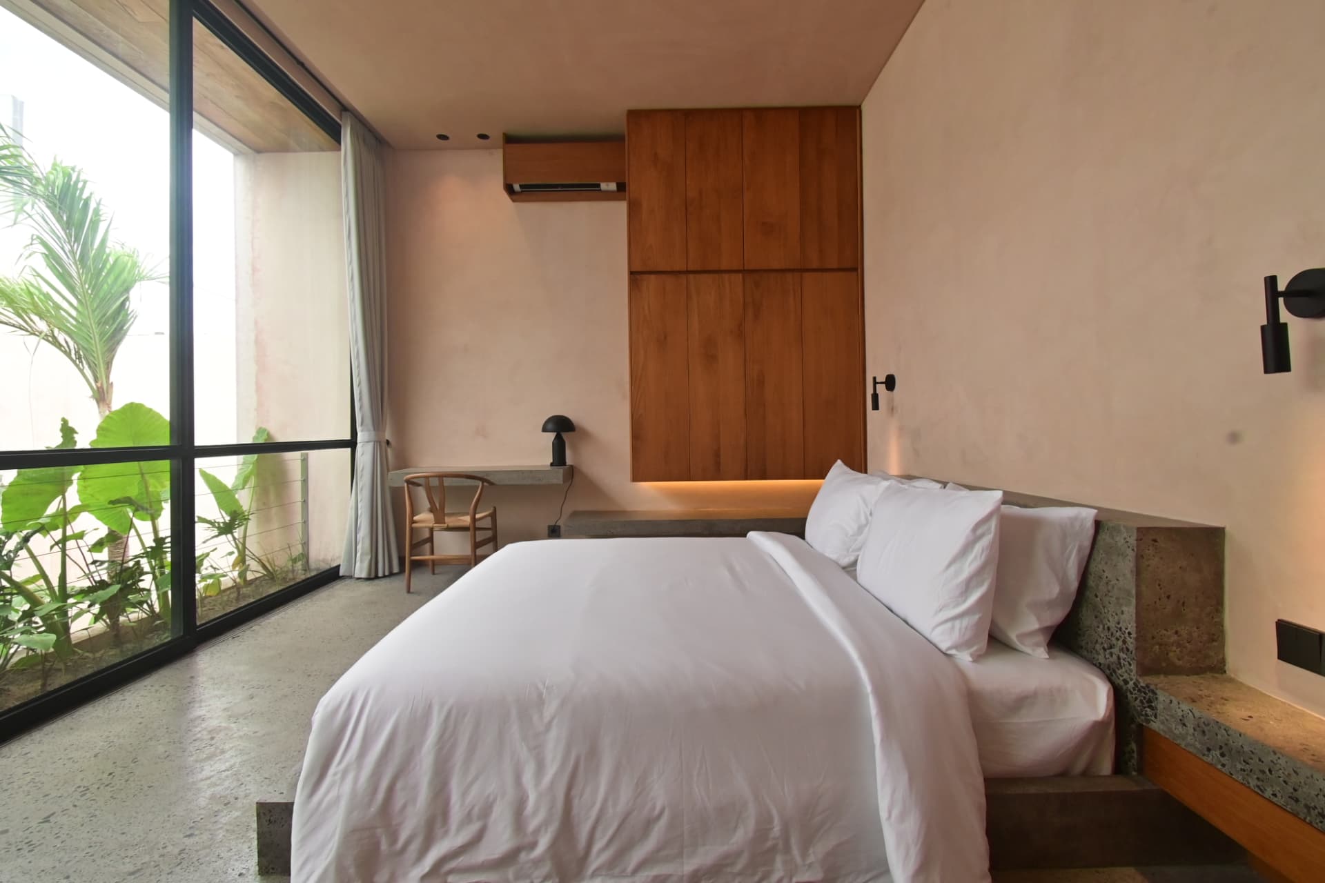 Pererenan 1 — guest bedroom opening to a planted courtyard