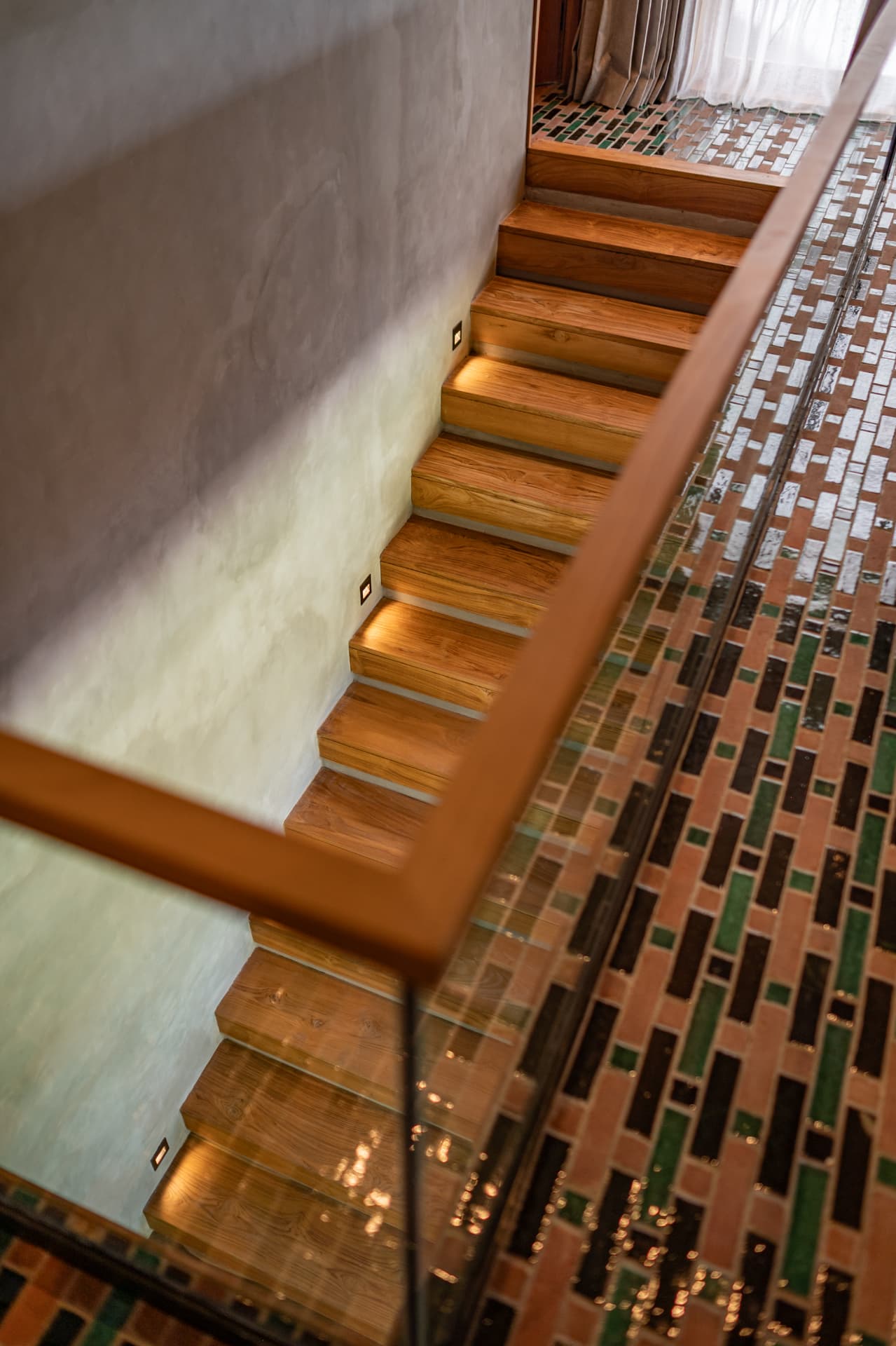 Timber stair over patterned mosaic flooring